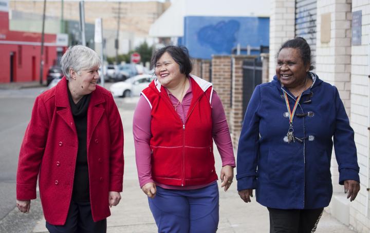 Three women smiling in the street