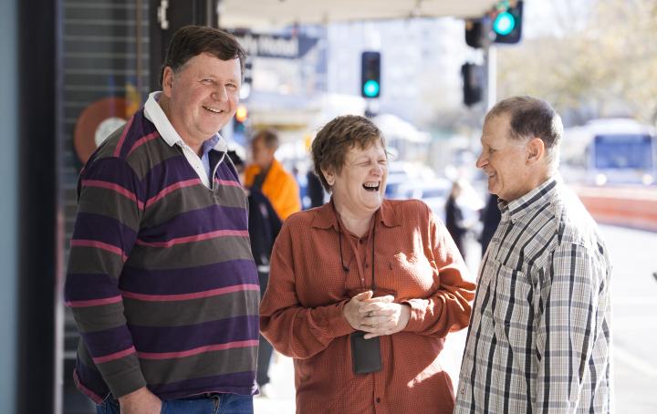 Three people smiling in the street