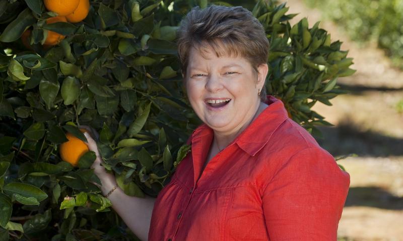 A woman holding an orange tree