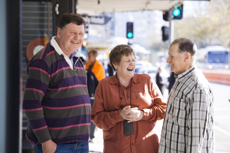 Three people smiling in the street