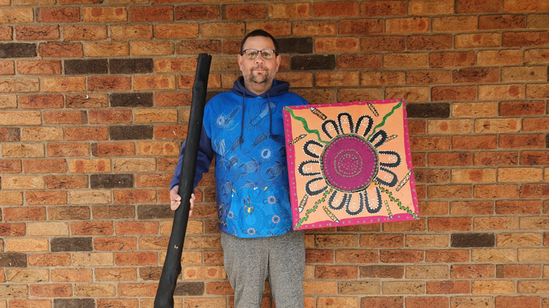 Nathaniel holding Abroginal artwork