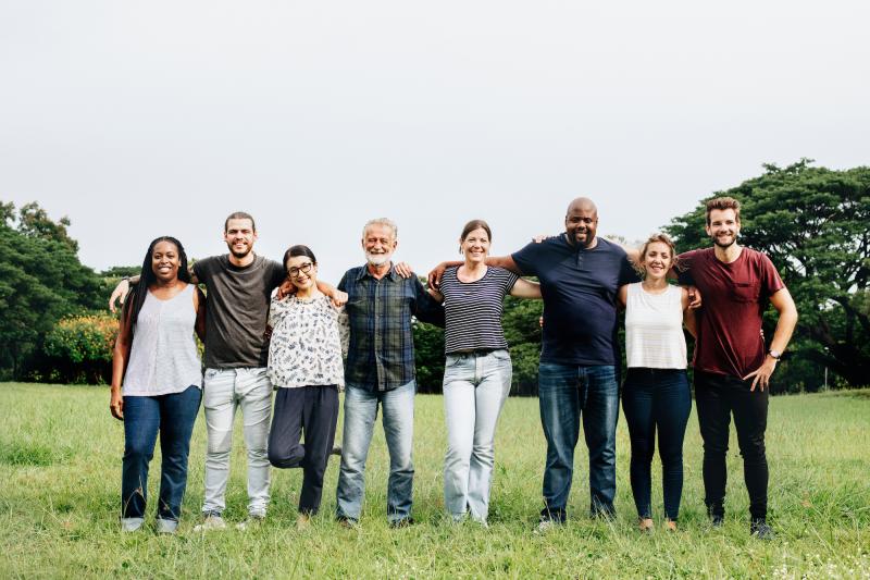 Eight people locking arms in a park