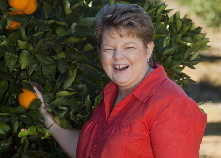 A woman holding an orange tree