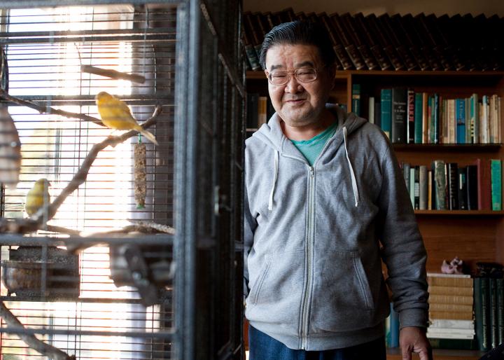 A man looking at birds in a cage