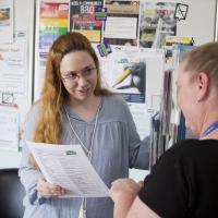 Two people reading from a piece of paper