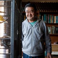 A man looking at birds in a cage