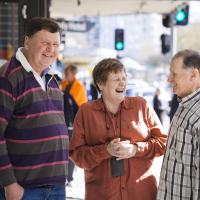 Three people smiling in the street